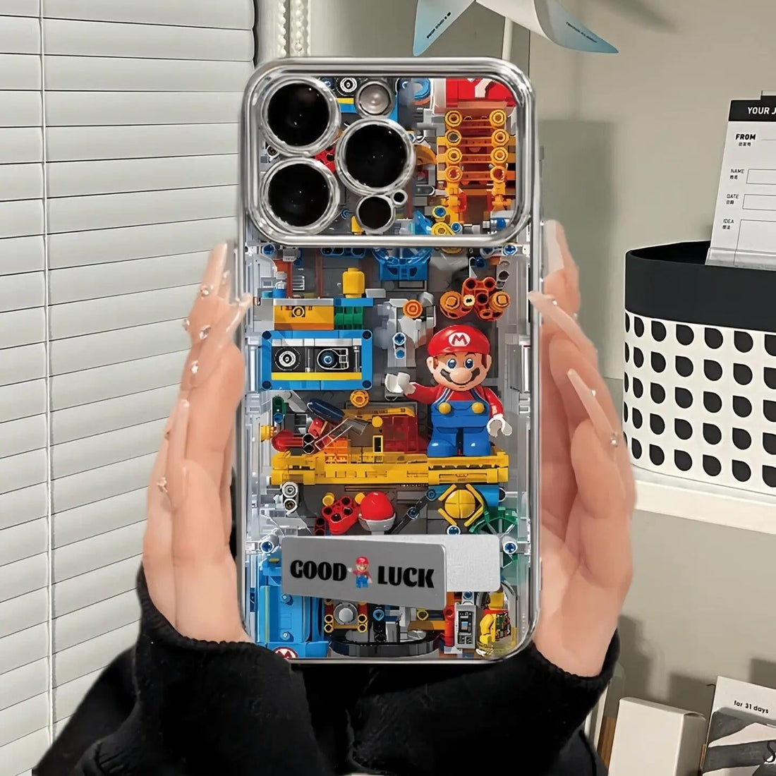 Phone case with LEGO-style design held by a person, featuring a character and text.